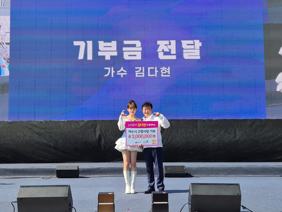 김다현이 여수시 고향사랑기부금 200만 원을 전달하는 모습으로 행사 무대에서 정기명 여수시장과 기념사진을 찍고 있다.