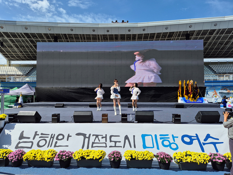 여수시민의 날 기념행사에서 김다현이 무대에서 공연하고 있다. 배경에는 대형 스크린과 꽃으로 장식된 무대가 보인다.