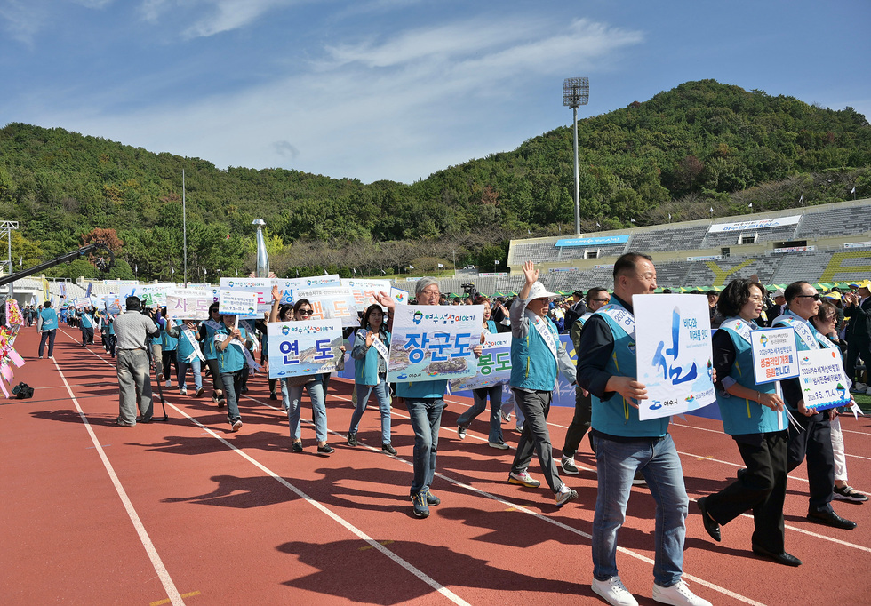여수시민의 날 기념행사에서 시민들이 해당행사를 상징하는 문구가 적힌 판넬을 들고 2026여수세계섬박람회를 홍보하는 행진을 하고 있다.