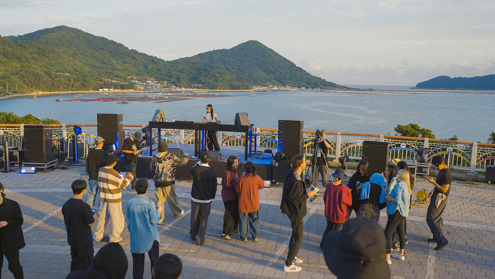 거문도 서도 놋길공원에서 열린 산다이 뮤직 페스티벌에서 DJ가 공연 중이며 관람객들이 즐기고 있는 모습