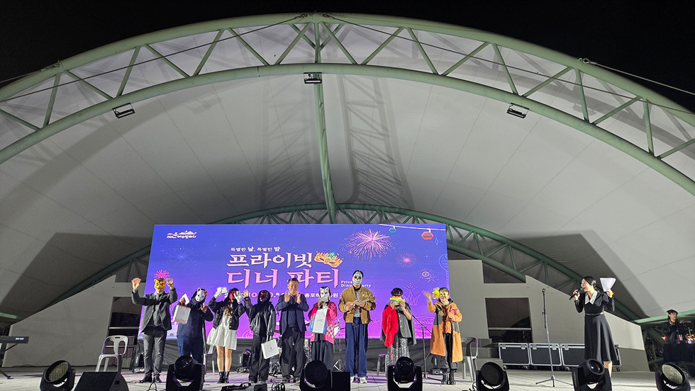 여수 종포해양공원에서 열린 프라이빗 디너 파티에서 참가자들이 가면을 쓰고 즐거운 시간을 보내고 있다.