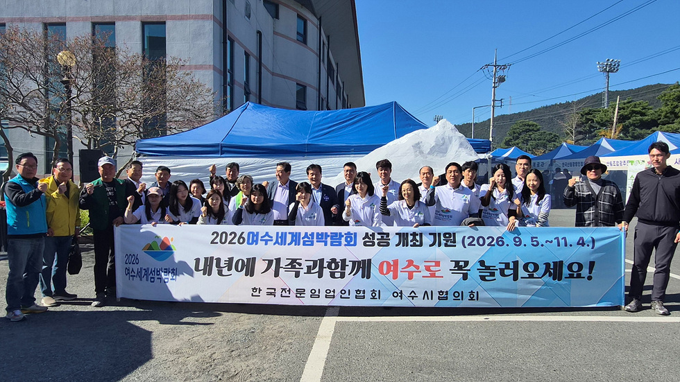 전남 임업인 한마음대회 행사장에서 참가자들이 ‘2026여수세계섬박람회 성공 개최 기원(2026.9.5.~11.4) 내년에 가족과 함께 여수로 꼭 놀러오세요!’라는 문구의 현수막을 들고 단체 사진을 찍는 모습