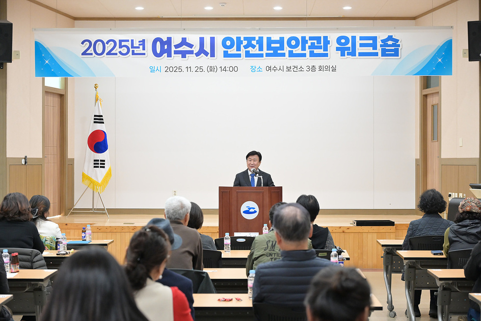 여수시 보건소 회의실에서 열린 2025년 여수시 안전보안관 워크숍에서 정기명 여수시장이 단상에서 인사말을 하고 있고, 참석자들이 책상에 앉아 강의를 듣고 있는 모습