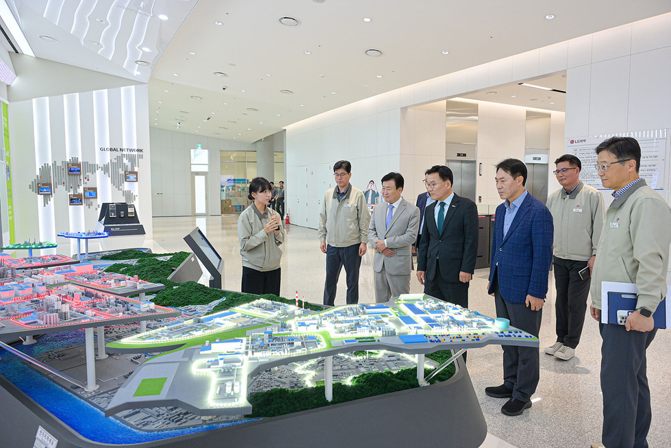 산업단지 전경 모형을 앞에 두고 기업 관계자가 설명하고 참석자들이 모형을 바라보며 청취하는 모습.