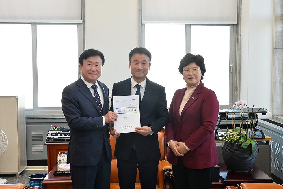 정기명 여수시장이 관계자와 함께 사무실에서 2026년도 정부 예산 관련 문서를 들고 기념 촬영하고 있다.