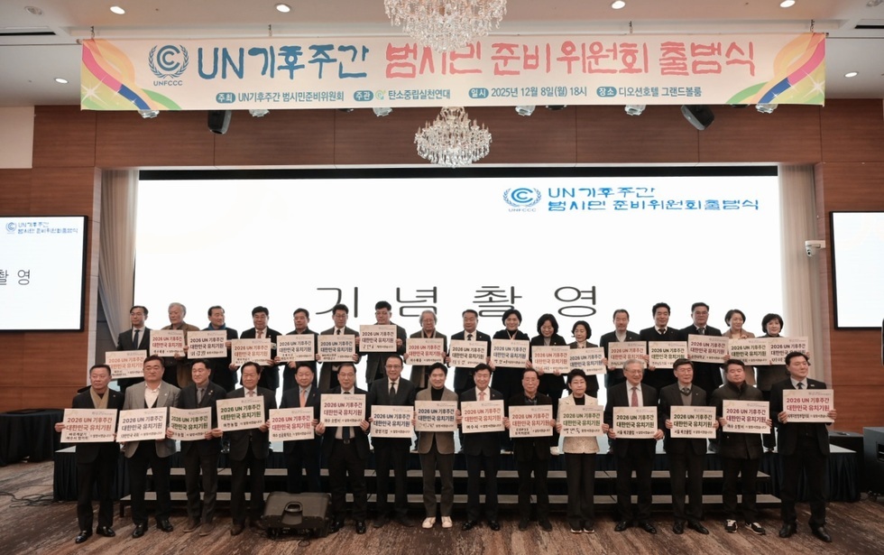 행사장 무대 앞에서 여러 인사가 단상에 서서 ‘2026 UN 기후주간 유치 지지’ 문구가 적힌 피켓을 들고 단체 기념촬영을 하는 모습.